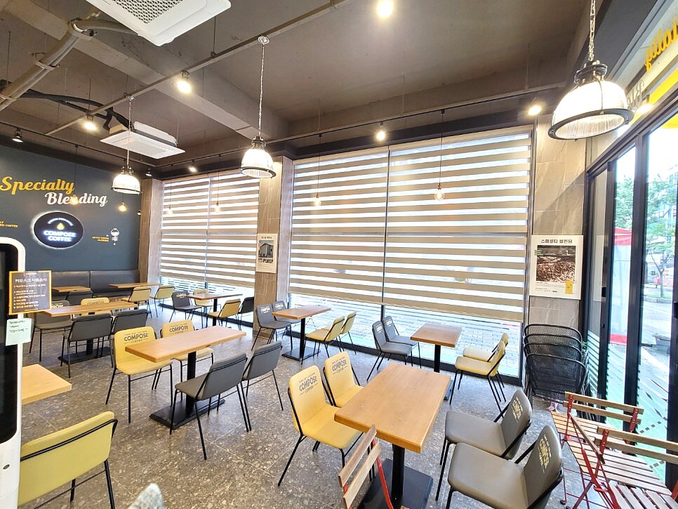 컴포즈커피 내부 옐로 브라운 인테리어와 우드룩 콤비블라인드 통창