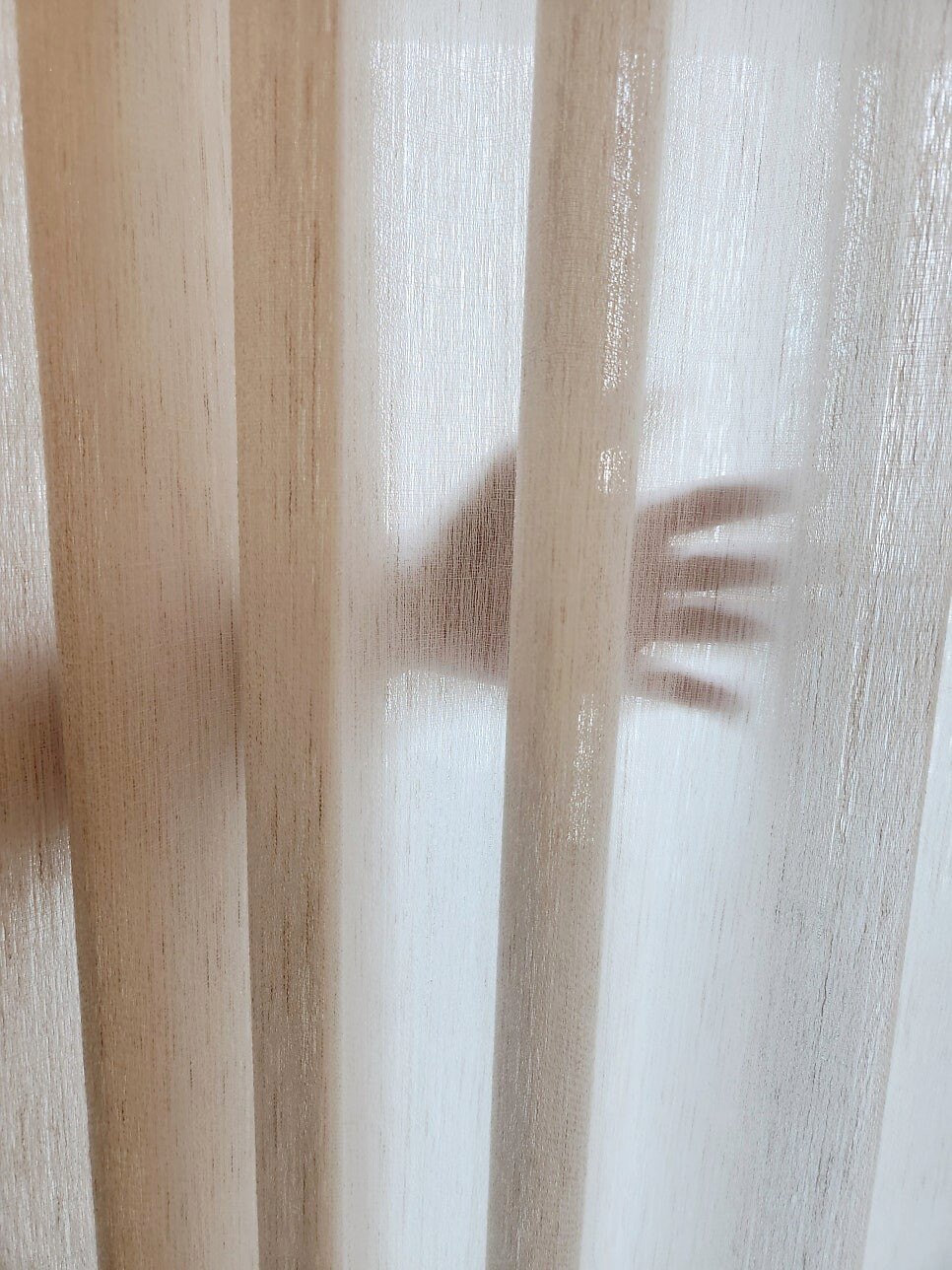 같은 수입 린넨 원단 뒤에 손을 대어 비치는 정도를 본 샘플 사진, 손 형체만 흐리게 비치는 정도의 밀도
