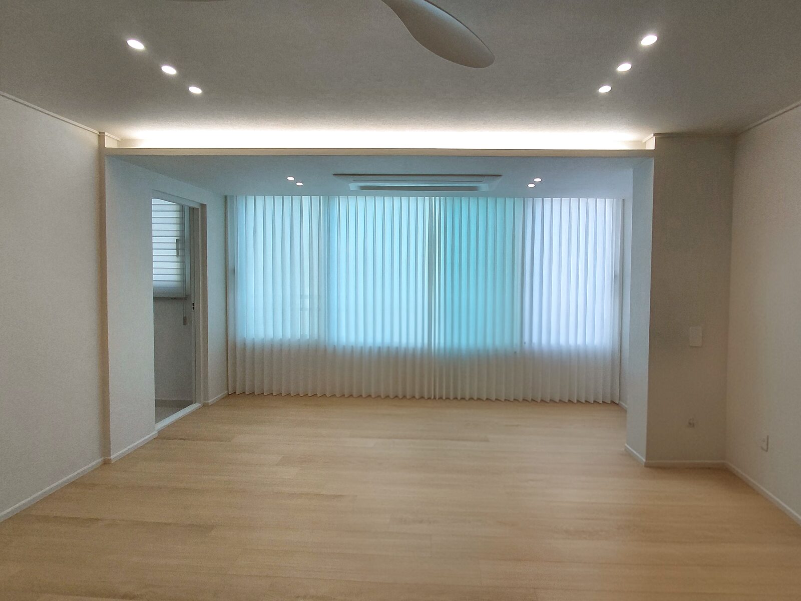 파크시엘 거실 정면, 넓은 창과 베란다 문 쪽 창을 같은 도톰 쉬폰 속커튼으로 이어 단 모습, 천장 실링팬과 밝은 마루